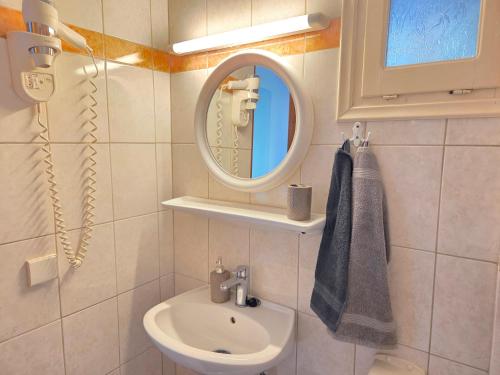 a bathroom with a sink and a mirror at Angela Studio in Ipsos
