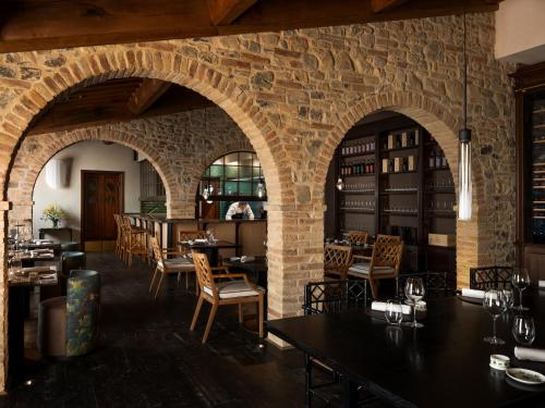 a restaurant with brick walls and tables and chairs at Fattoria di Vegi in Castellina in Chianti