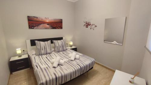 a bedroom with a bed with pillows and a mirror at El Faro-Beach in Cullera