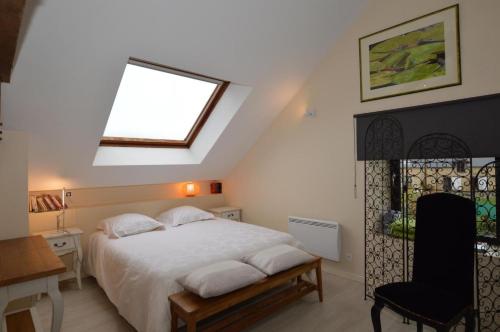 a bedroom with a bed with a window and a chair at Les Gîtes des Portes de Bretagne in La Chapelle-Saint-Aubert