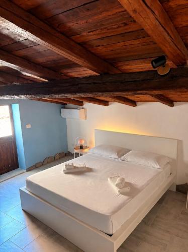 a large white bed in a room with wooden ceilings at Casa Van Gogh Catania in Catania