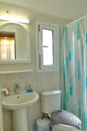 a bathroom with a white toilet and a sink at Small farmhouse by M in Egina