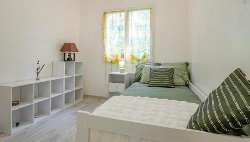a small bedroom with a bed and a window at La caillotine in Rosières-près-Troyes