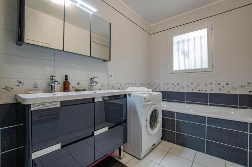 a bathroom with a washing machine and a sink at La caillotine in Rosières-près-Troyes