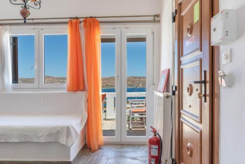 a bedroom with a bed with an orange curtain at Agnadi Apartment in Serifos Chora