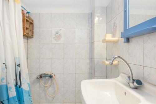 a bathroom with a sink and a shower curtain at Agnadi Studio in Serifos Chora