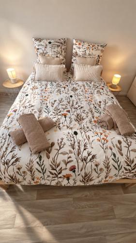 a bed with a white comforter and pillows at Le Cocooning - 4 voyageurs - Jardin,Terrasse in Saint-Nazaire