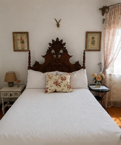 a bedroom with a white bed with a wooden headboard at Sunset Vista Apartment B in Mação