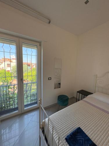 a bedroom with a bed and a large window at Victoria House Pompei in SantʼAntonio Abate