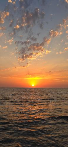 a sunset over the ocean with the sun setting at jibo in Grigoleti