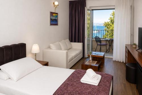 a hotel room with a bed and a living room at Hotel Lipa in Postira