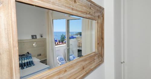a mirror on a wall with a view of the ocean at Sant Roc Apartments a Minute From The Beach in Calella de Palafrugell