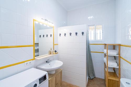 a white bathroom with a sink and a mirror at Casa Rural Villa Manantial in La Puebla de Cazalla