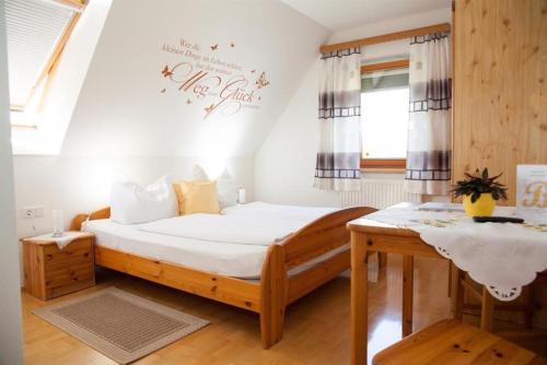 a small bedroom with a bed and a table at Obst- und Weinbauernhof BERNHARD in Leutschach