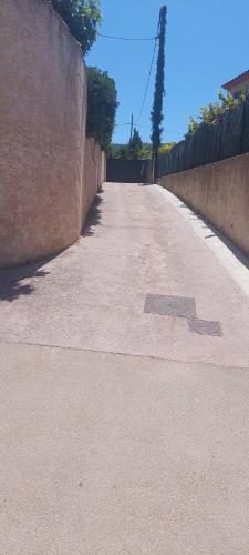 an empty road with a wall on the side at La cigala in Le Pradet