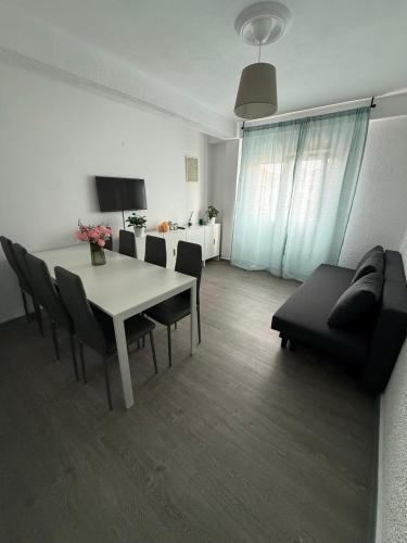 a living room with a table and chairs and a couch at Amplio piso para 8 a 2 min de Playa Santa Marina, 3 habitaciones in Ribadesella