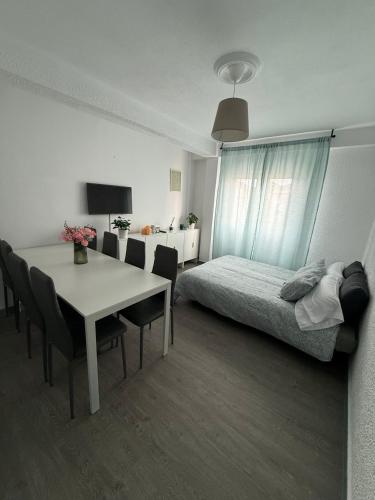 a bedroom with a bed and a table with chairs at Amplio piso para 8 a 2 min de Playa Santa Marina, 3 habitaciones in Ribadesella
