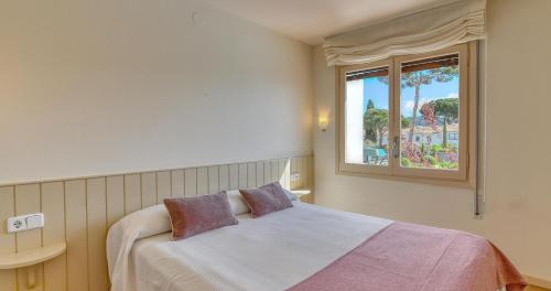 a bedroom with a bed and a window at Penyagolosa in Calella de Palafrugell