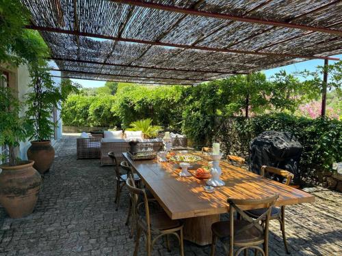 a wooden table and chairs under a pergola at 199 - Quinta dos Carvalhos in Castelo Branco