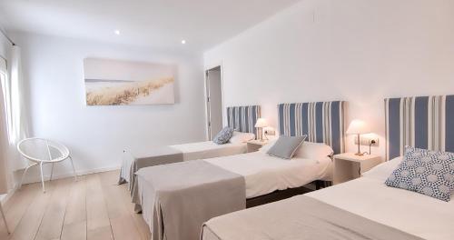 a hotel room with two beds and a painting on the wall at Sant Roc Apartments a Minute From The Beach in Calella de Palafrugell