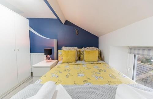 a bedroom with a yellow bed with yellow pillows at Egremont Hide Away - Perfect contractor accommodation - Close to Sellafield in Woodend