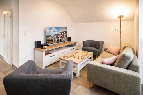 a living room with two couches and a tv at Der VechteSchober - Nordhorn in Nordhorn