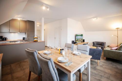 a dining room and living room with a table and chairs at Der VechteSchober - Nordhorn in Nordhorn
