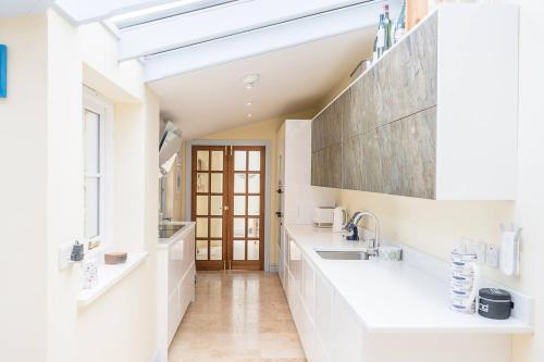 a kitchen with white counters and a sink at The Light House, Southwold in Southwold