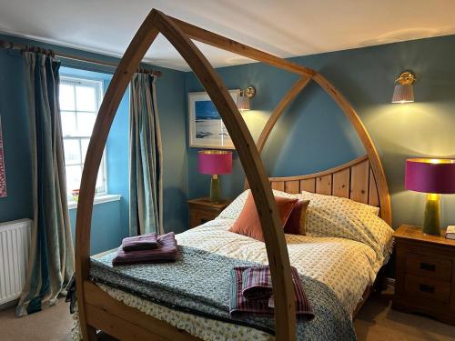 a bedroom with a bed with a wooden frame at Planners House in Saint Monance