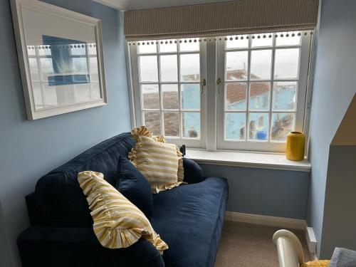 a living room with a blue couch and two windows at Planners House in Saint Monance