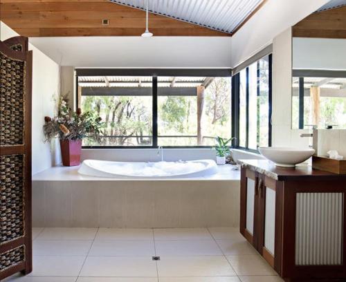 a large bathroom with a tub and a large window at SilverSprings Spa Retreat Pet Friendly Cottages and Glampings in Metricup