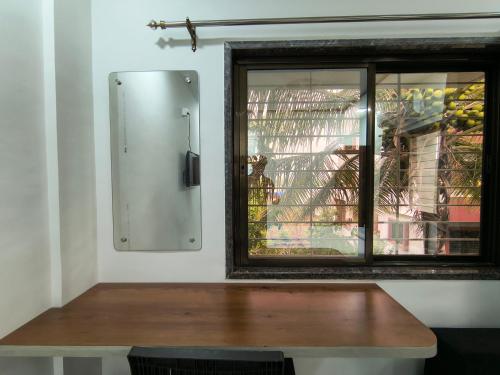 a wooden table in a room with a window at Stay Origin, In Nashik in Nashik