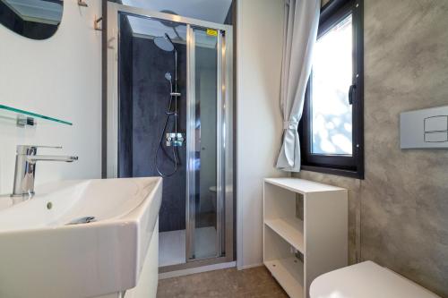 a bathroom with a white sink and a shower at Etrusco Camping Village in Casiano