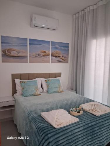 a bedroom with a bed with two towels on it at Divine Duplex Próximo ao Oficina 23 Kite Surf in Caucaia