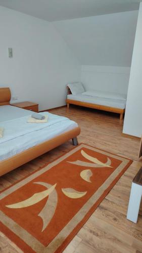 a room with two beds and a rug on the floor at Casa Madalina in Săpânța