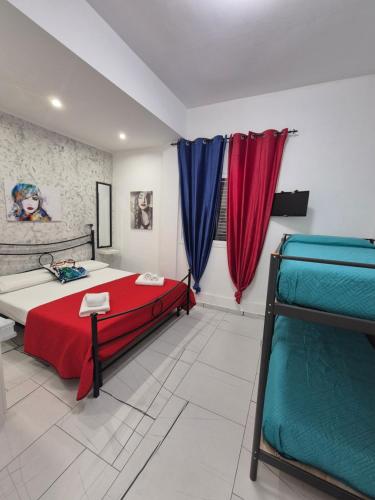 a bedroom with a bed and red and blue curtains at Albicocche house Catania in Catania