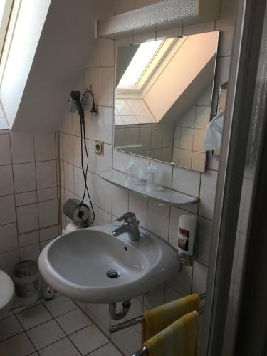 a bathroom with a sink and a mirror at Hotel & Restaurant Park Cafe ISA in Erfurt