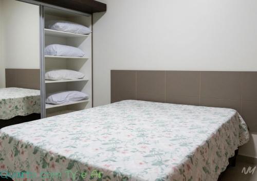a bedroom with a bed and a shelf with pillows at Park Veredas Flat 310 Premium in Rio Quente