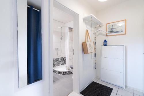 a white bathroom with a shower and a toilet at Ort Lemkenhafen Sundbrise in Fehmarn