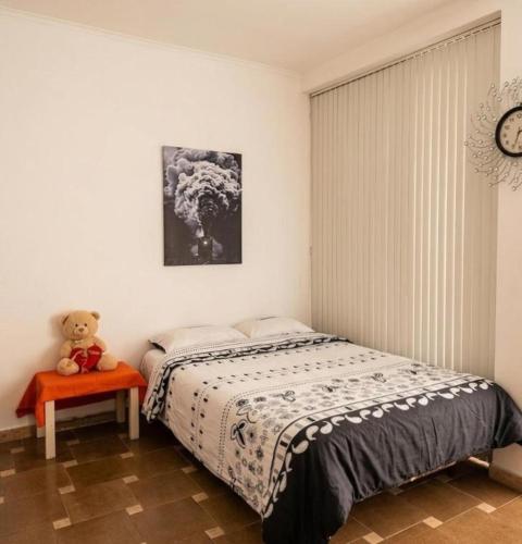 a bedroom with a bed and a teddy bear on a table at Private Room & Terrace in Skopje