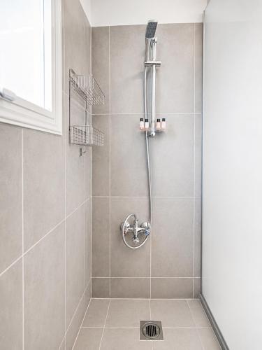 a shower with a shower head in a bathroom at Pantelia Apartment Paralimni in Paralimni
