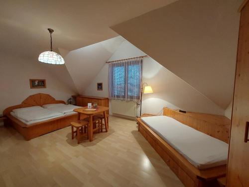 a attic room with two beds and a table at Reiterhof Sonja in Apetlon