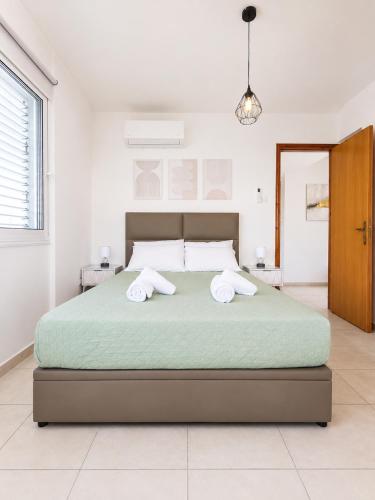a bedroom with a large bed with two towels at Pantelia Apartment Paralimni in Paralimni