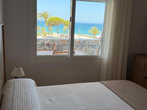 a bedroom with a window with a view of the ocean at Espejo del mar in Mojácar