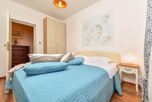 a bedroom with a bed with blue pillows on it at Apartment Modrusani 1561 in Žminj
