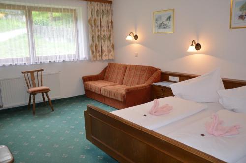 a hotel room with two beds and a couch at Gasthof "Zur Gemütlichkeit" in Bschlabs