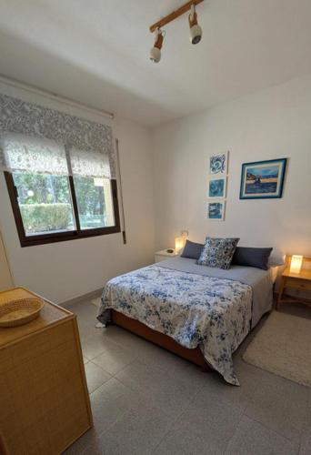 a bedroom with a bed and a window at Gaviotas piscina comunitaria in Calafat