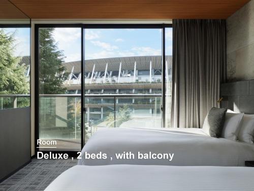 a bedroom with a bed with a view of a stadium at Mitsui Garden Hotel Jingugaien Tokyo Premier in Tokyo