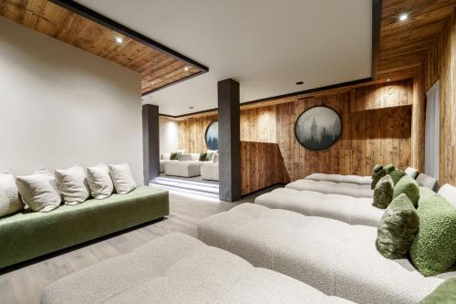 a living room with white furniture and wooden walls at EL CIASEL in Canazei
