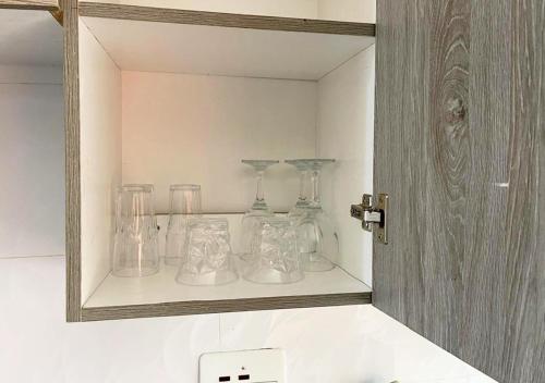 a shelf with glass bottles and glasses on it at Sofies's Apartments in Lusaka